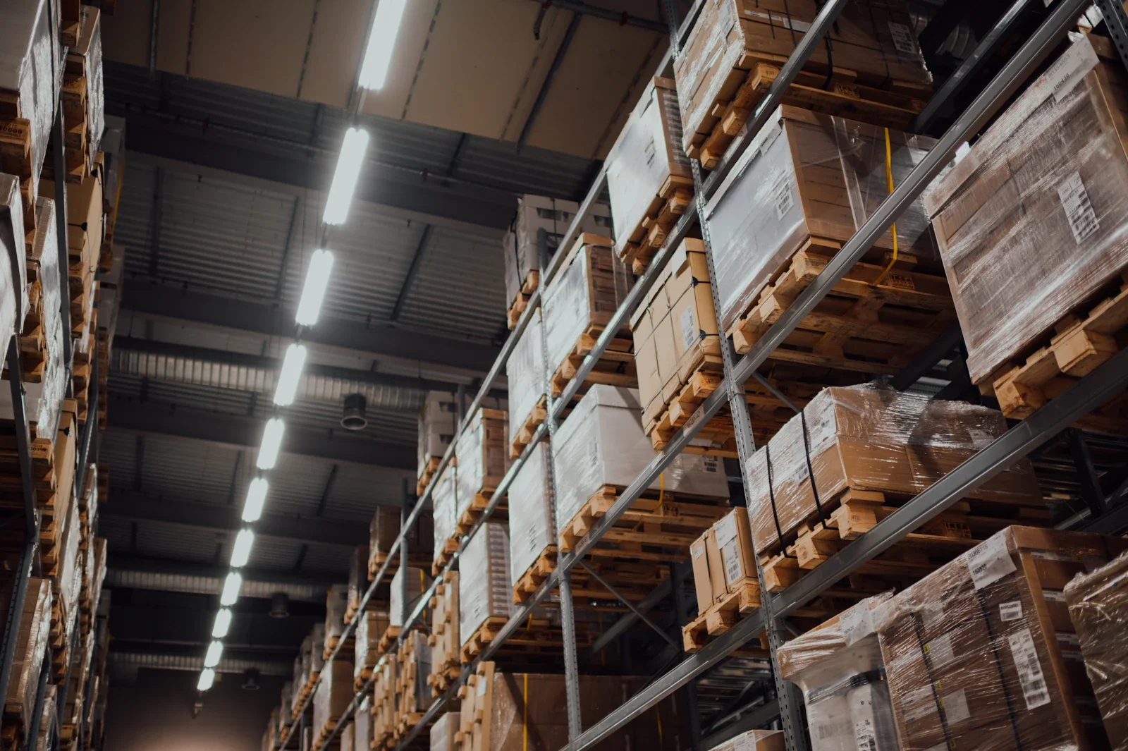 Stivuitor manipulând paleți de marfă la rampa de descărcare a unui depozit logistic